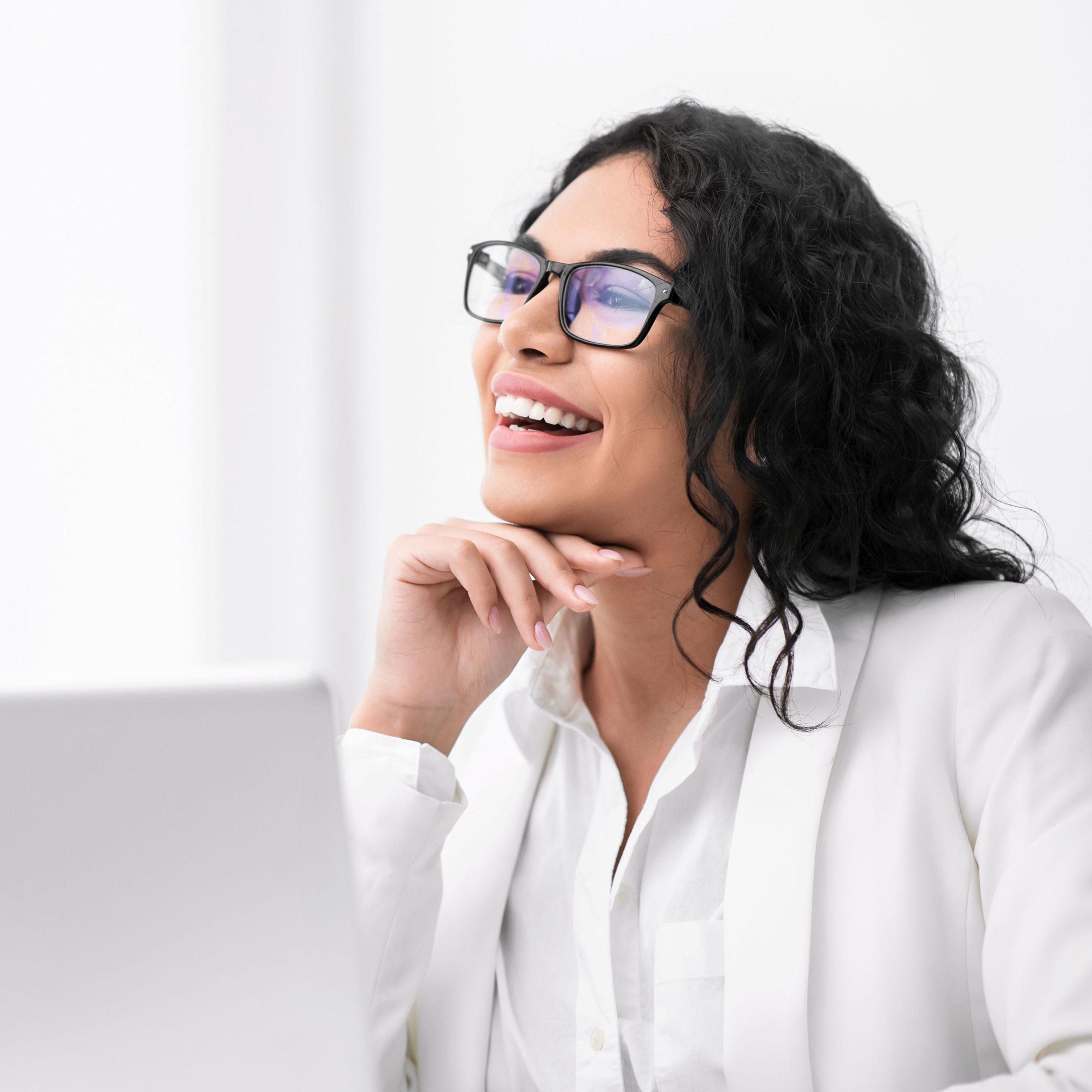 Businesswoman smiling and sitting in front of a laptop